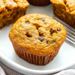 Pumpkin Breakfast Recipes: Delicious & Nutritious Start to Your Day 11 Single pumpkin muffin in a white muffin liner on plate.