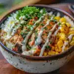 Street corn chicken rice bowl with grilled chicken, rice, and creamy elote topping